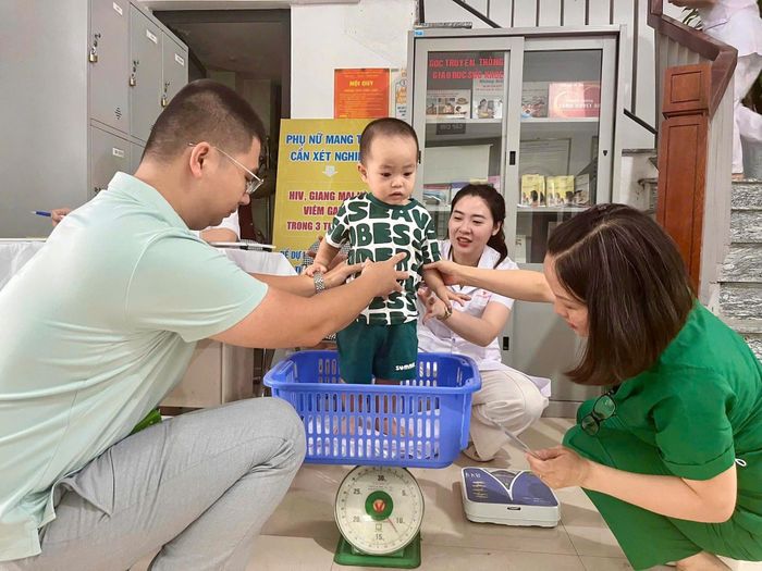 Cán bộ y tế thực hiện cân đo cho trẻ khi đến khám.