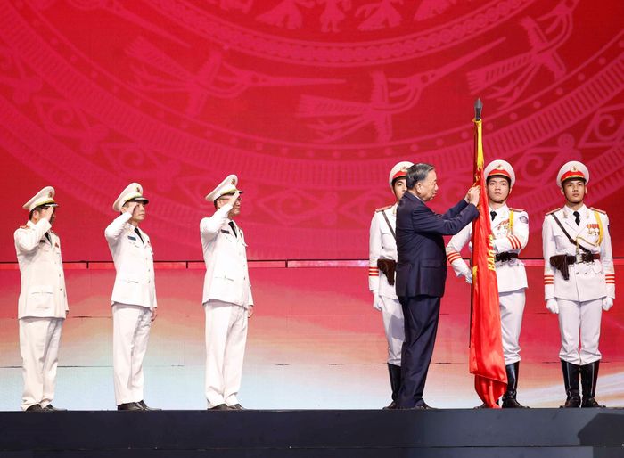 Tổng Bí thư, Chủ tịch nước Tô Lâm gắn Huân chương Sao vàng lên lá cờ truyền thống của Lực lượng An ninh nhân dân. Ảnh: Thống Nhất – TTXVN
