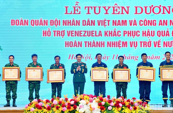 Đại tướng, Bộ trưởng Quốc phòng Phan Văn Giang trao Huân chương Bảo vệ Tổ quốc hạng Nhì và hạng Ba tặng các cá nhân thuộc lực lượng cứu hộ, cứu nạn Quân đội nhân dân Việt Nam và Công an nhân dân Việt Nam. (Ảnh: Thanh Giang)