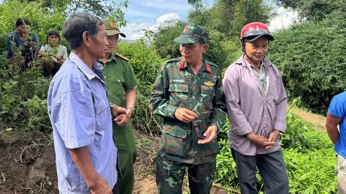 Ông Y Nghe Pang Taih (bìa phải) và ông Y Biêng Ntơr (bìa trái) xác định vị trí an táng liệt sĩ để Đội K51 quy tập.