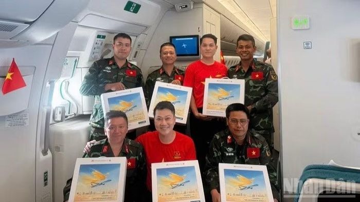 Trên chuyến bay, các tiếp viên của Vietnam Airlines mặc áo và cài huy hiệu cờ đỏ sao vàng, mang theo sắc màu Tổ quốc trong không gian khoang bay. Hình ảnh ấy hòa chung vào không khí trang trọng của hành trình, như một lời cảm ơn gửi đến các cán bộ, chiến sĩ đã hoàn thành xuất sắc nhiệm vụ và trở về trong niềm tự hào.