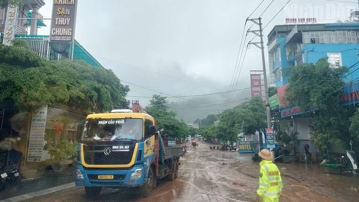 Lực lượng cảnh sát giao thông điều tiết giao thông tại khu vực bị ngập úng trung tâm xã Mường La.