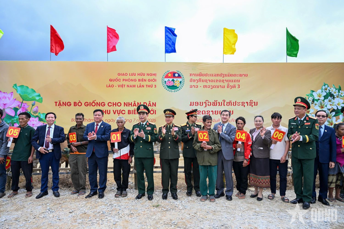 Đại tướng Phan Văn Giang và Đại tướng Khamliang Outhakaysone cùng các đại biểu trao bò giống tặng các hộ dân của Lào ở biên giới.