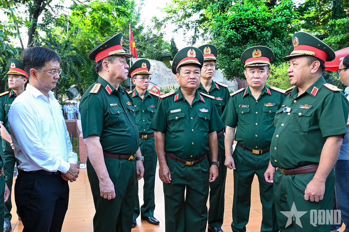 Thiếu tướng Nguyễn Thành Trung (bìa phải) báo cáo Đại tướng Nguyễn Trọng Nghĩa về công tác tìm kiếm, cất bốc hài cốt liệt sĩ.