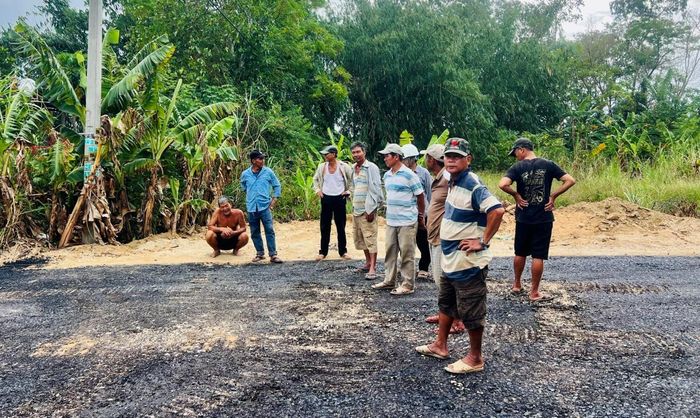 Người dân thôn Lệ Bắc vui mừng đi xem thi công thảm nhựa.