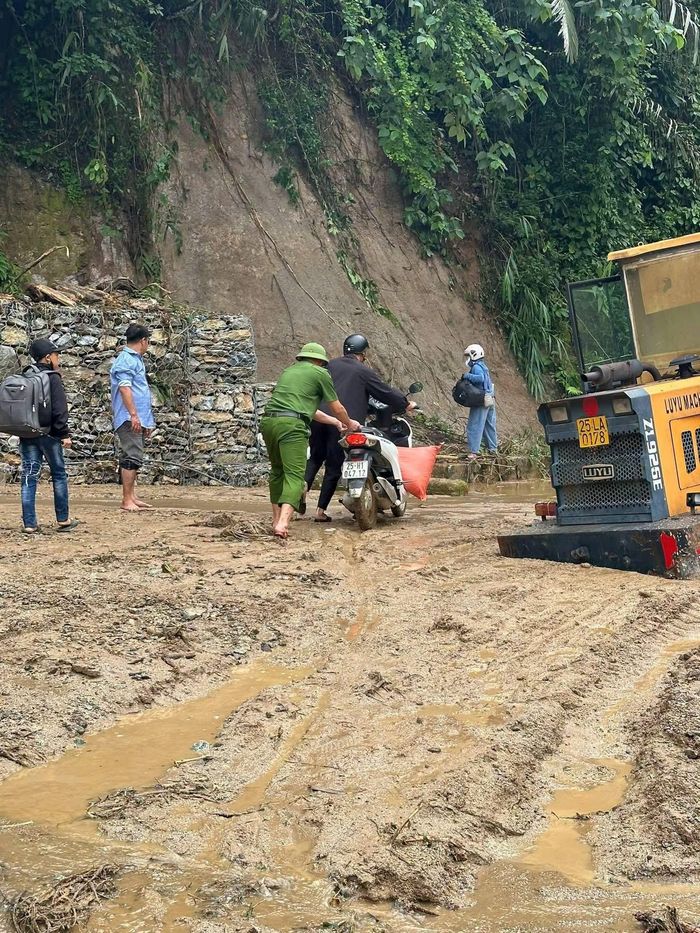  Lực lượng chức năng tỉnh Lai Châu hỗ trợ người dân qua các điểm đường bị mưa lũ ảnh hưởng. Ảnh: CÔNG AN TỈNH LAI CHÂU 