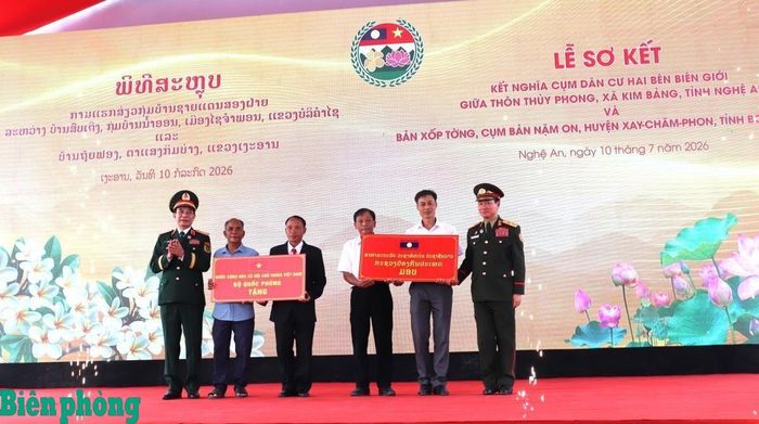 Đại tướng Phan Văn Giang và Đại tướng Khăm Liêng-U Thạ Cay Sỏn trao quà cho nhân dân thôn Thủy Phong và bản Xốp Tờng. Ảnh: Viết Lam