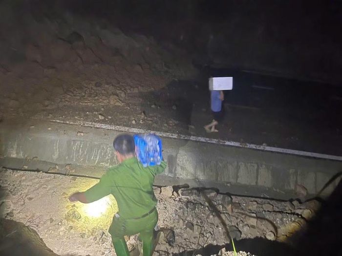 Lực lượng công an xuyên đêm vượt qua những đoạn sạt lở nguy hiểm đưa các nhu yếu phẩm tiếp tế cho những người bị mắc kẹt