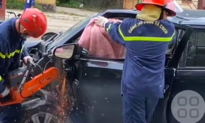 Lực lượng chức năng cắt cánh xe đưa nạn nhân vụ tai nạn ra ngoài (Ảnh cắt từ clip)