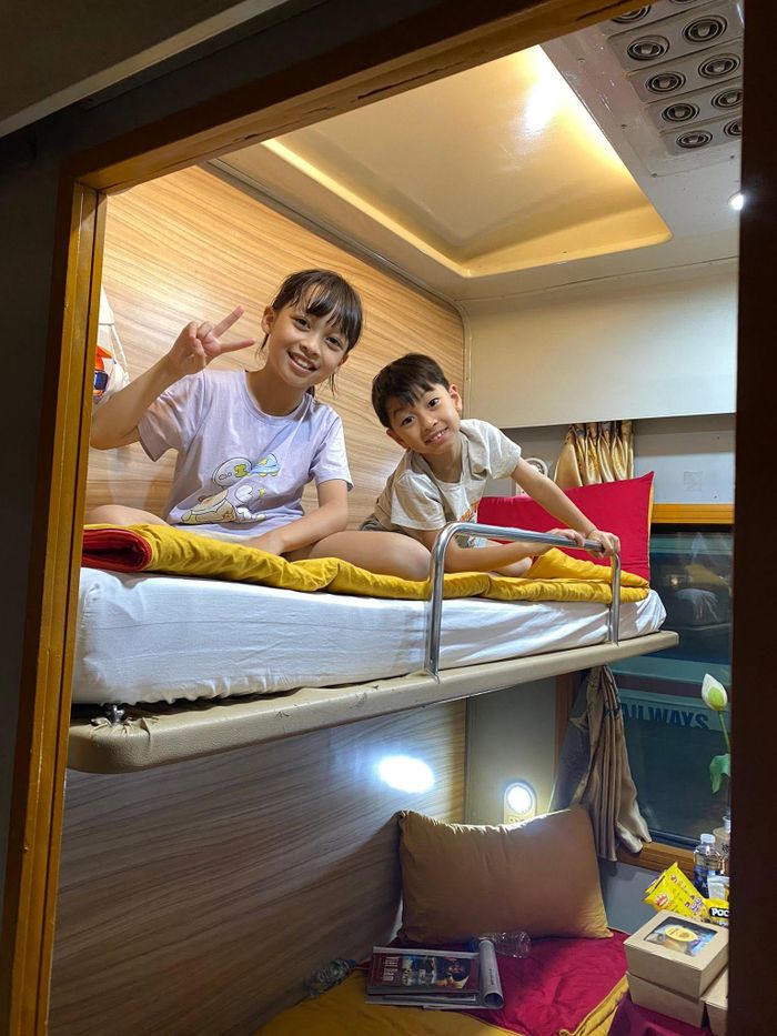 2 bạn nhỏ thích thú khi di chuyển bằng tàu hỏa