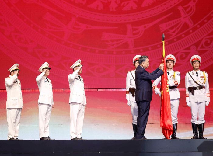 Tổng Bí thư, Chủ tịch nước Tô Lâm gắn Huân chương Sao vàng lên lá cờ truyền thống của Lực lượng An ninh nhân dân. Ảnh: Thống Nhất – TTXVN