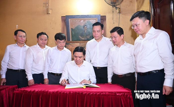 Phó Bí thư Thường trực Tỉnh ủy xúc động ghi vào Sổ truyền thống lời tri ân. Ảnh: Thành Cường