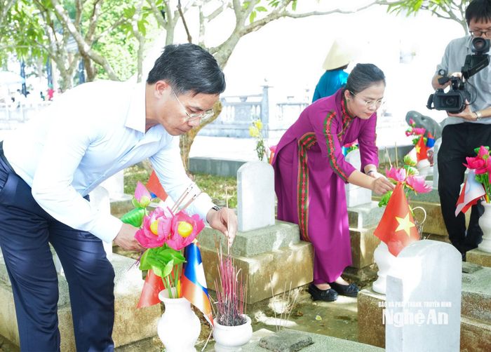 Đồng chí Phạm Đức Ấn - Ủy viên Ban Chấp hành Trung ương Đảng, Thống đốc Ngân hàng Nhà nước Việt Nam và đồng chí Võ Thị Minh Sinh - Phó Bí thư Tỉnh ủy, Chủ tịch Ủy ban MTTQ Việt Nam tỉnh Nghệ An dâng hương trước các phần mộ liệt sĩ tại Nghĩa trang Liệt sĩ Quốc tế Việt - Lào. Ảnh: Mai Hoa