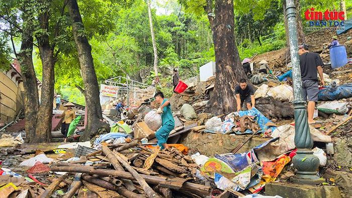 Lực lượng chức năng và người dân phối hợp thu gom vật liệu, vệ sinh khu vực sau tháo dỡ.