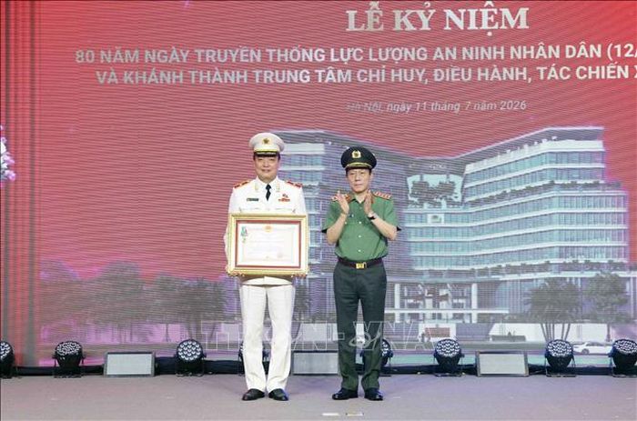 Đại tướng Lương Tam Quang, Bộ trưởng Bộ Công an trao Huân chương Bảo vệ Tổ quốc hạng Ba cho Thiếu tướng Nguyễn Bá Tuấn, Phó Cục trưởng Cục Quản lý xuất nhập cảnh. Ảnh: Phạm Kiên/TTXVN