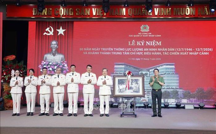 Đại tướng Lương Tam Quang, Bộ trưởng Bộ Công an trao tặng Bức ảnh Bác Hồ với lực lượng An ninh nhân dân cho Cục Quản lý xuất nhập cảnh. Ảnh: Phạm Kiên/TTXVN