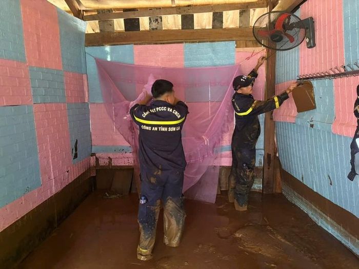 Lực lượng Cảnh sát phòng cháy chữa cháy và cứu nạn cứu hộ hỗ trợ nhân dân di chuyển tài sản bị ngập do mưa lũ. Ảnh: Công an tỉnh Sơn La