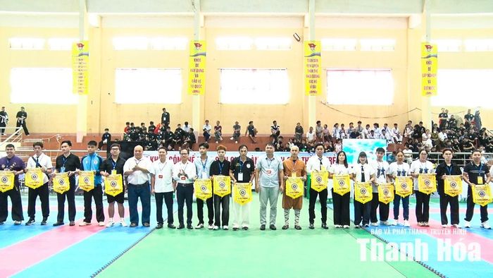 Đại diện Sở Văn hóa, Thể thao và Du lịch và xã Hà Trung tặng cờ lưu niệm cho các CLB và võ đường tham dự giải.