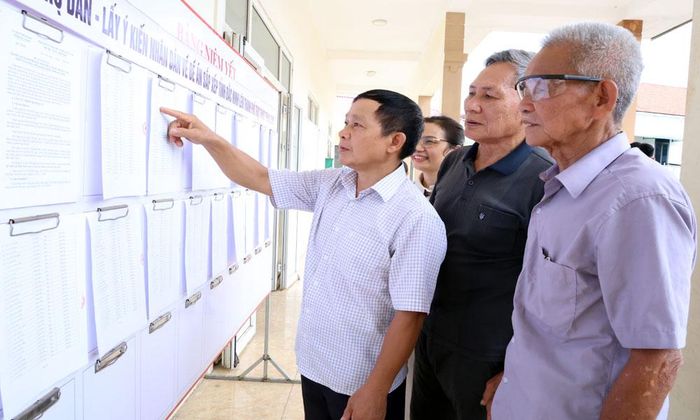 Cử tri đại diện hộ gia đình tại xã Sơn Động tìm hiểu thông tin trước khi ghi ý kiến đối với Đề án thành lập thành phố Bắc Ninh trực thuộc Trung ương.
