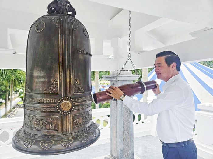  Đồng chí Lê Xuân Lợi thỉnh chuông tại Nghĩa trang liệt sĩ quốc gia Tông Khao. 