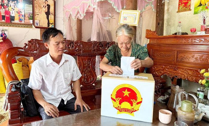 Thành viên tổ lấy ý kiến thôn Đồng Bài, xã An Lạc đưa hòm phiếu đến hộ gia đình trong thôn để lấy ý kiến.