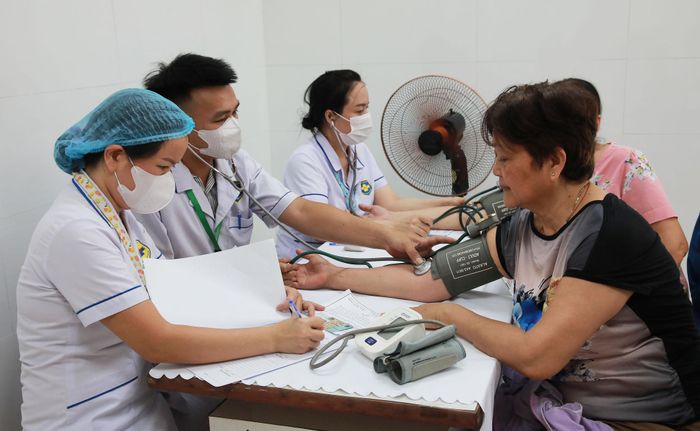 Cán bộ Trạm Y tế phường Thanh Khê đo huyết áp cho người dân. Ảnh: ĐẮC MẠNH