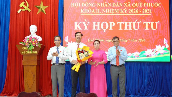 Lãnh đạo HĐND xã Quế Phước tặng hoa chúc mừng ông Uông Văn Hải được bầu giữ chức Phó Chủ tịch HĐND xã. Ảnh: MINH THÔNG
