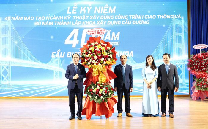 Lãnh đạo Đại học Đà Nẵng (bìa trái) tặng hoa chúc mừng tại lễ kỷ niệm. Ảnh: NGỌC HÀ