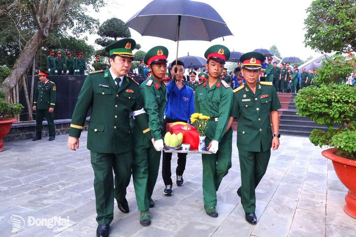 Các đồng chí thủ trưởng Bộ Chỉ huy Quân sự thành phố thực hiện nghi thức di dời hài cốt các anh hùng liệt sĩ từ đài tưởng niệm về khu vực an táng. Ảnh: Nguyệt Hà