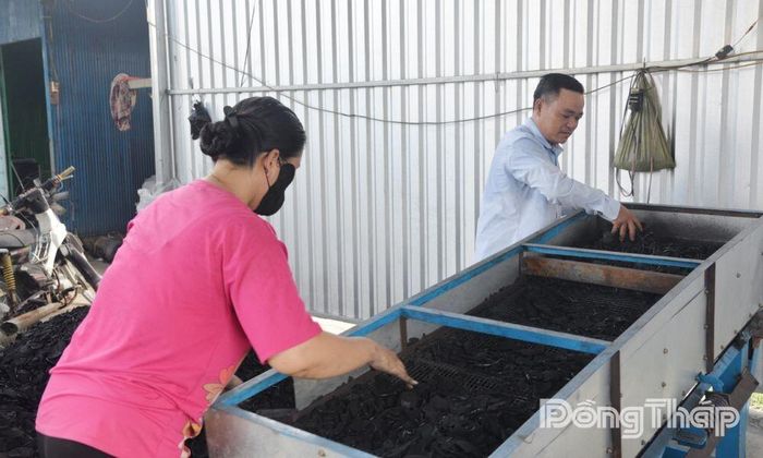 Vợ chồng anh Mai Đức Lại bên mẻ than thành phẩm.