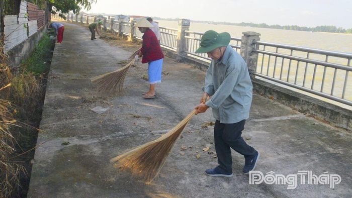 Cựu chiến binh và người dân khu phố Tân Long tham gia dọn vệ sinh trên bờ kè Bắc khu phố Tân Long.