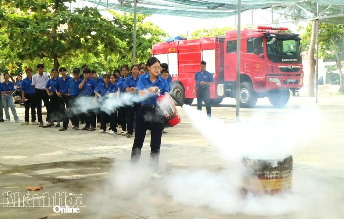 Học sinh thực hành kỹ năng dập lửa bằng bình chữa cháy xách tay.