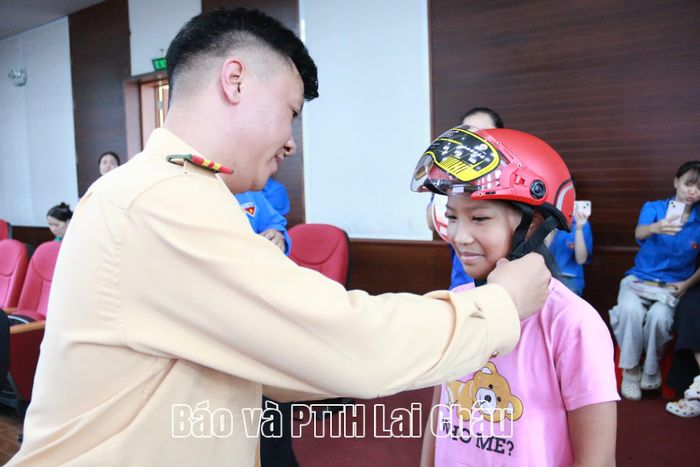 Cán bộ Phòng Cảnh sát giao thông tặng mũ bảo hiểm cho thiếu nhi.