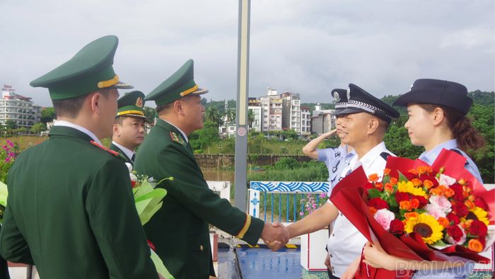 Đoàn đại biểu Trạm Kiểm tra Biên phòng xuất nhập cảnh Hà Khẩu (Trung Quốc) đón đoàn đại biểu 4 đồn Biên phòng tỉnh Lào Cai tại vạch phân định đường biên giới Cửa khẩu Quốc tế Lào Cai trước khi tham dự hội đàm.