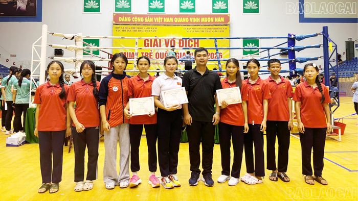 Đoàn vận động viên Muay trẻ Lào Cai chụp ảnh lưu niệm cùng huấn luyện viên.