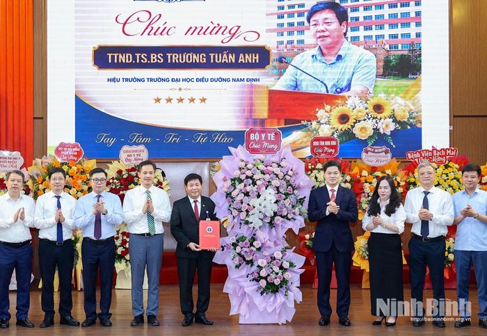 Đồng chí Vũ Mạnh Hà, Ủy viên dự khuyết Trung ương Đảng, Thứ trưởng Thường trực Bộ Y tế và đại diện Bộ Y tế tặng hoa chúc mừng tân Hiệu trưởng.