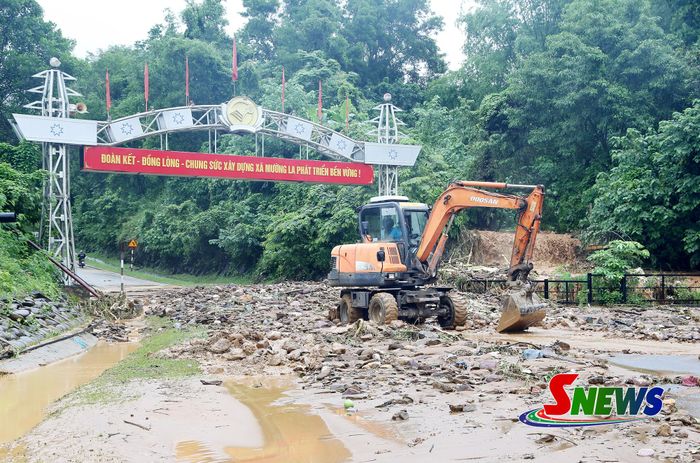 Xã Mường La huy động máy móc xử lý điểm tắc trên quyến quốc lộ 279D, khu vực đầu vào trung tâm xã Mường La.