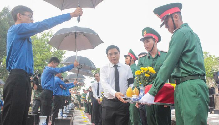 Phó Thủ tướng Chính phủ Nguyễn Văn Thắng đưa hài cốt các liệt sĩ vào vị trí an táng. Ảnh: Văn Dũng
