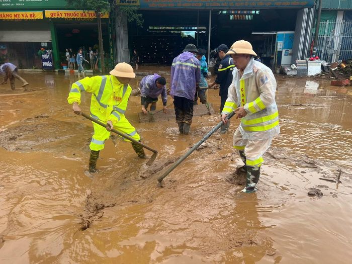 CSGT Công an Sơn La nạo bùn, khơi thông cống rãnh do mưa lớn kéo dài.