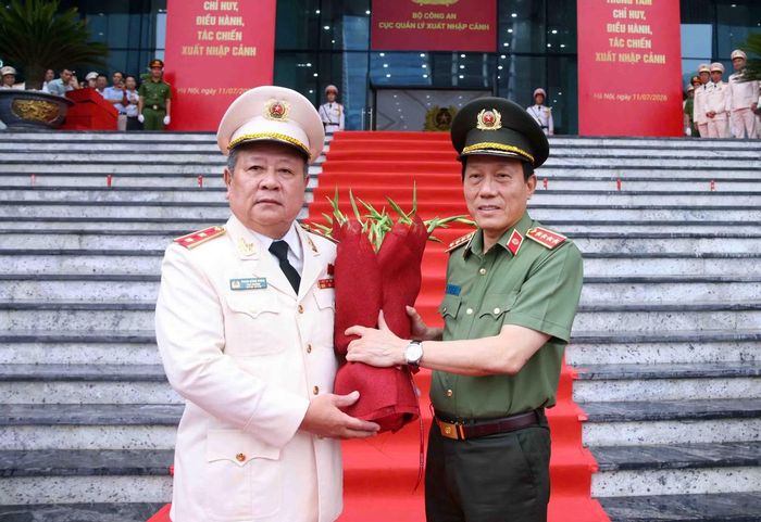 Trung tướng Phạm Đăng Khoa, Cục trưởng Cục Quản lý xuất nhập cảnh tặng hoa, chào đón Bộ trưởng Lương Tam Quang đến dự buổi lễ.