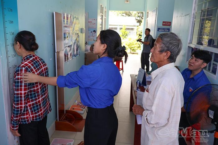 Đoàn viên, thanh niên hỗ trợ đo chiều cao, cân nặng cho người cao tuổi để hoàn thiện thủ tục khám nhanh chóng.