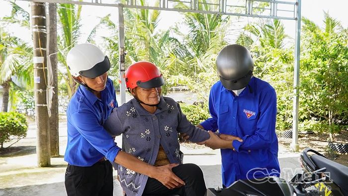 Tình nguyện viên ân cần hỗ trợ những người lớn tuổi đi lại khó khăn.