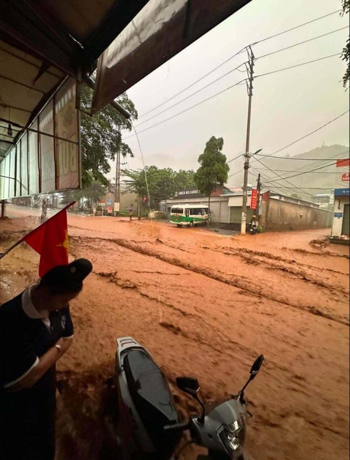 Nước lũ tràn về đường Tiểu khu 2, xã Mường La gây ngập cục bộ, đoạn ngập sâu nhất hơn một mét, sáng 11/7. Ảnh: Ngoc Trang. 