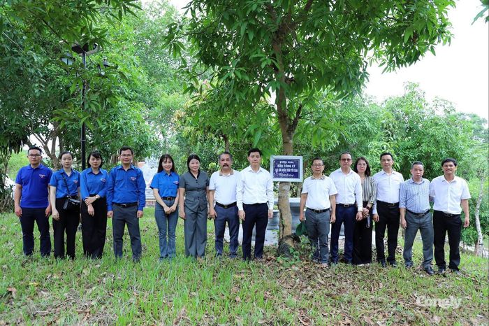 Tập thể cán bộ, nhân viên, phóng viên, biên tập viên bên vườn xoài do Báo Công lý trồng nằm trong khuôn viên Nghĩa trang Liệt sĩ Quốc gia Trường Sơn.