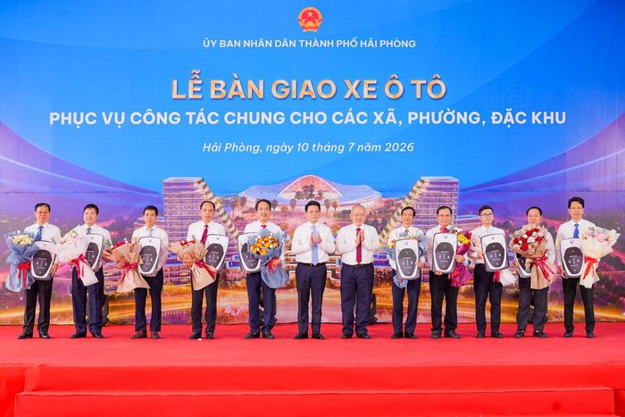 Lãnh đạo thành phố trao biểu trưng bàn giao xe ô tô điện cho đại diện các địa phương.