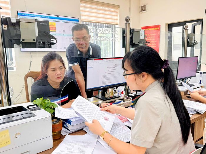 Các cán bộ công chức Thi hành án dân sự thành phố Hà Nội hỗ trợ người dân hoàn thiện các thủ tục hành chính. Ảnh: Hồng Nhung