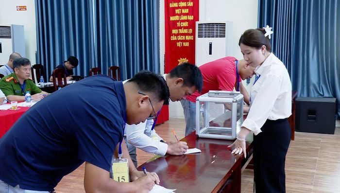 Khách hàng ký xác nhận vào phiếu đấu giá đất. Ảnh: Đức Duy