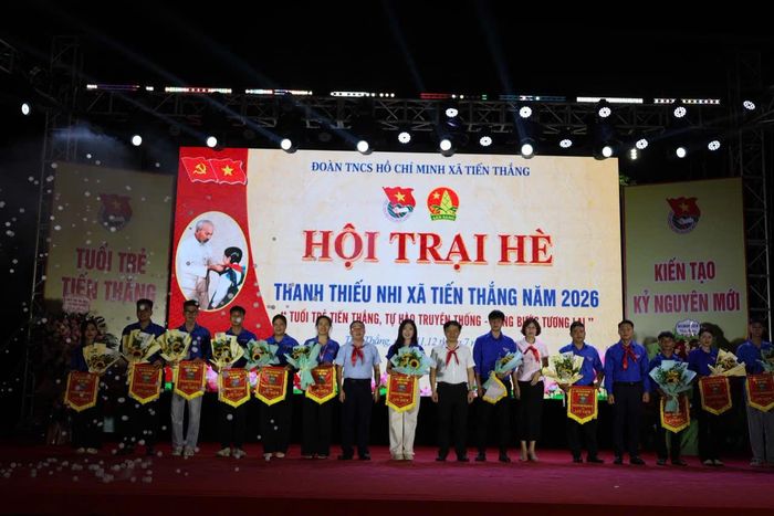 Các đại biểu tặng cờ lưu niện cho các đơn vị tham gia hội trại hè. Ảnh: PV