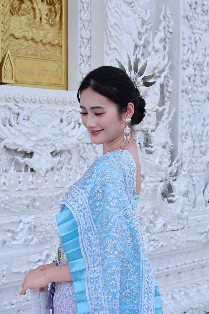 Ở từng khung hình, Ý Nhi đều ghi điểm bởi thần thái nhẹ nhàng, nụ cười tươi tắn cùng những cử chỉ mềm mại. Từ góc nghiêng khoe đường nét gương mặt thanh tú cho đến khoảnh khắc chắp tay theo nghi thức chào đặc trưng của người Thái, Hoa hậu Ý Nhi đều mang đến cảm giác thanh lịch và nền nã.