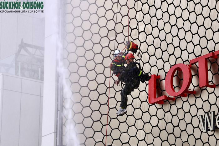 Lực lượng Cảnh sát PCCC&CNCH triển khai phương án cứu người từ tầng cao bằng hệ thống dây cứu nạn.